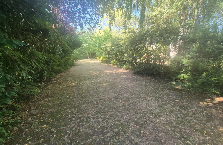 Maison bel étage de caractère avec grand jardin arboré et garage.